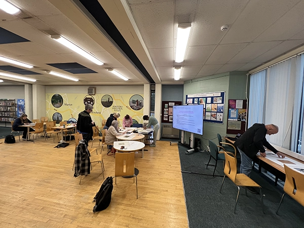 Exhibition display featuring participant photographs and written personal statements documenting individual life experiences